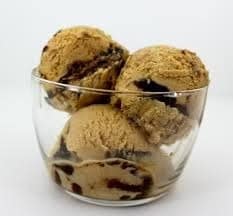 A swirl of golden butterscotch sauce drizzled over creamy vanilla ice cream, highlighting the sweet and indulgent dessert flavor.