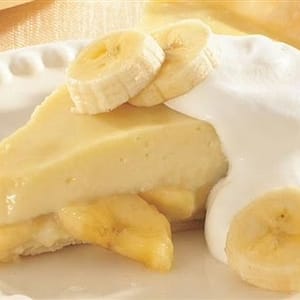 Fresh banana slices topped with a swirl of whipped cream, highlighting the sweet and creamy banana dessert flavor.