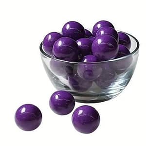 Purple bubblegum pieces with fresh grapes on the side, showcasing the sweet and juicy candy flavor.