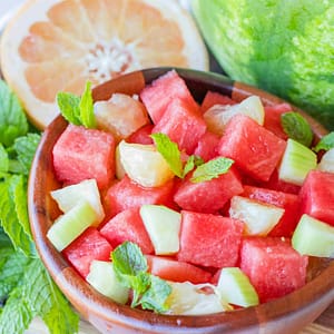 Fresh slices of pink grapefruit paired with juicy watermelon wedges, showcasing the sweet and tangy fruit blend.