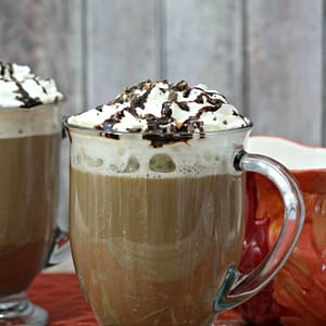 A frothy cappuccino alongside a creamy dessert topped with buttery crumble, highlighting the rich coffee and sweet bakery flavor.