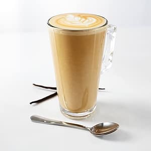 A steaming cup of vanilla latte topped with frothy milk and a drizzle of vanilla syrup, highlighting the smooth coffee and sweet cream flavor.